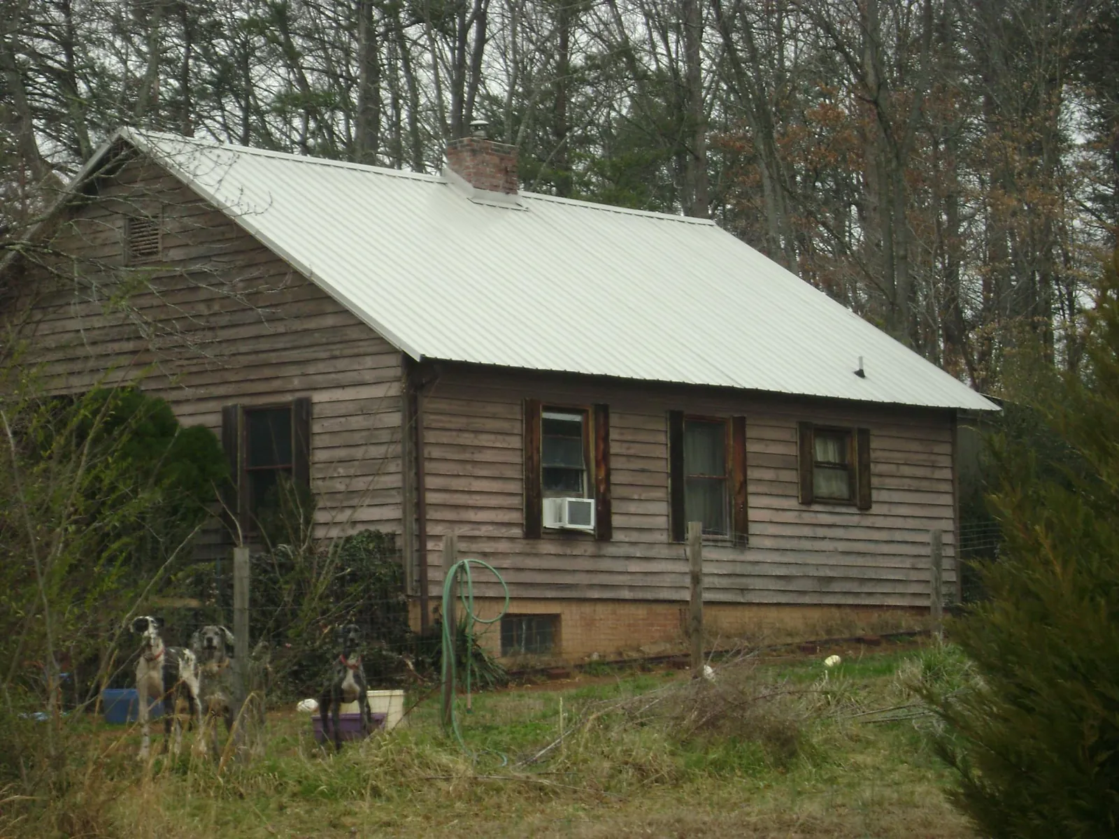 White metal roof on an old wood sided farmhouse, from a Metal Roof Installation job in Roanoke